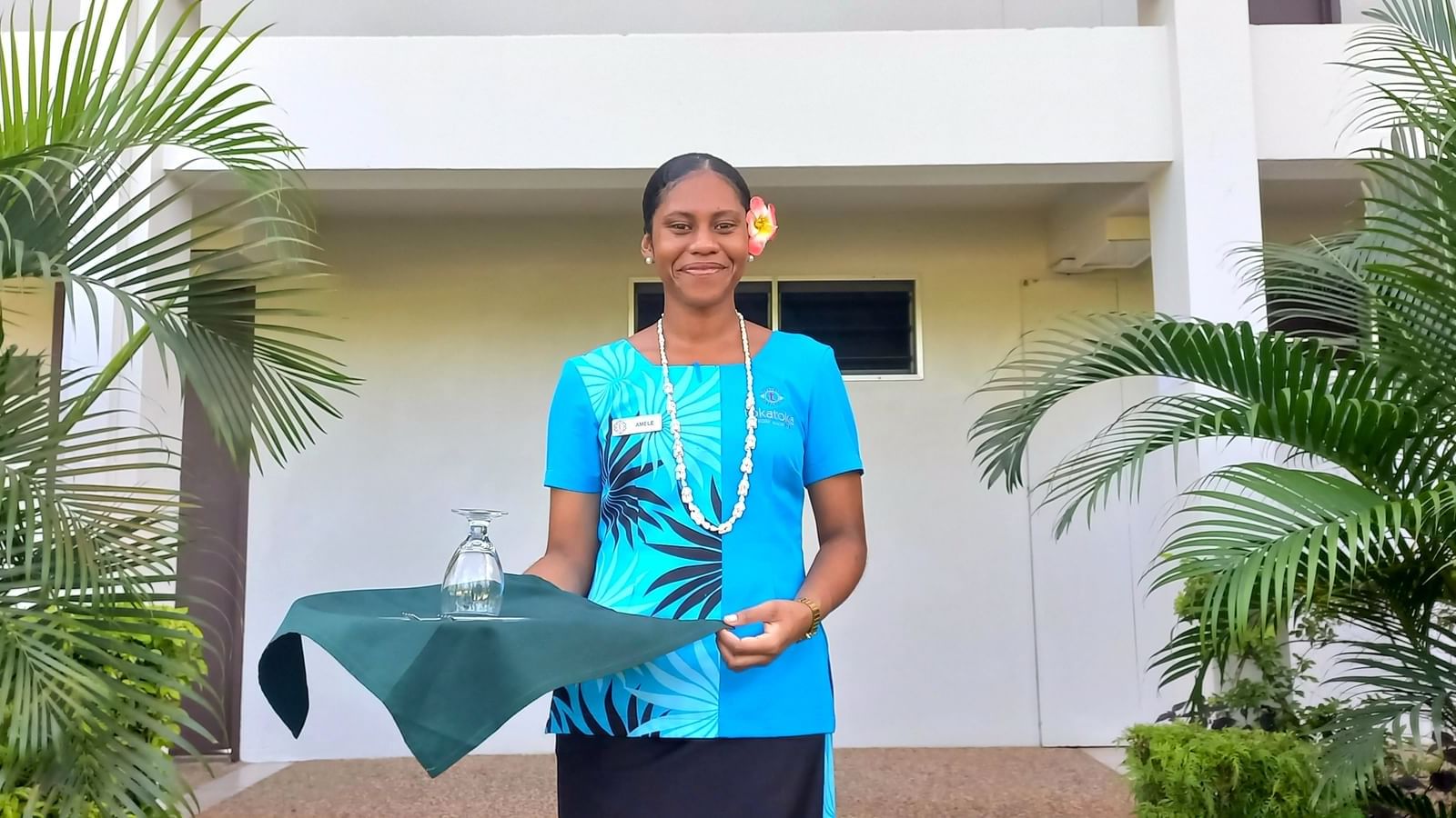 Female room server holding a tea tray at Tokatoka Resort