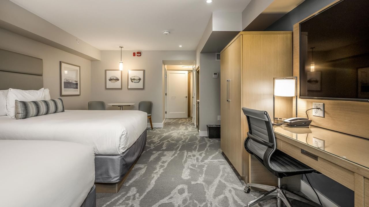 View of two queen beds, work desk and tv in our Coast Accessible Two Queens Bedroom