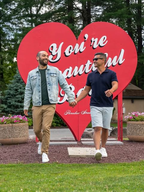Men holding hands by a Lovers sign, featuring Spring Festivals near Cove Pocono Resorts