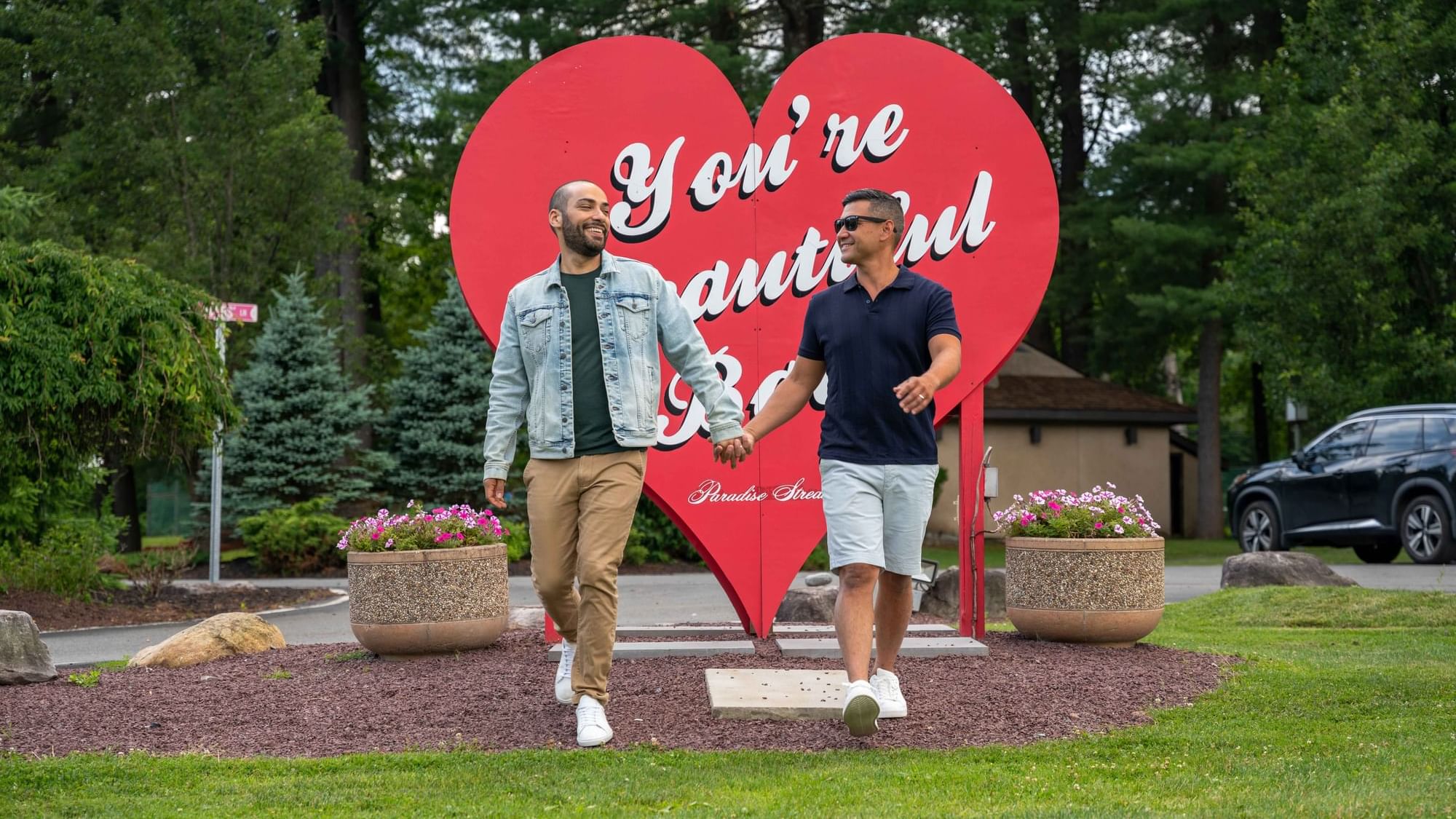 Men holding hands by a Lovers sign, featuring Spring Festivals near Cove Pocono Resorts