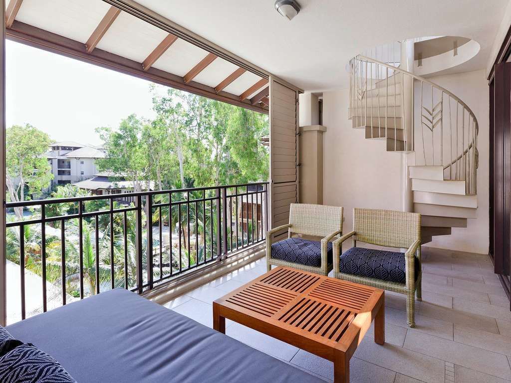 Balcony with a cozy loungers and a spiral staircase in Two-Bedroom Apartments at Pullman Palm Cove Sea Temple Resort & Spa