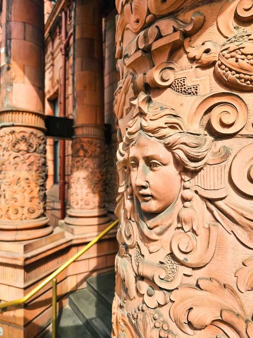 Close-up of terracotta column with a woman's face at The Met Hotel Leeds, highlighting historic architecture in England