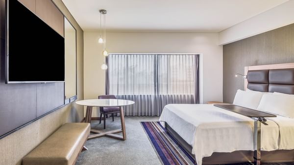 Cama cómoda y TV en habitación accesible en FA Hotels & Resorts