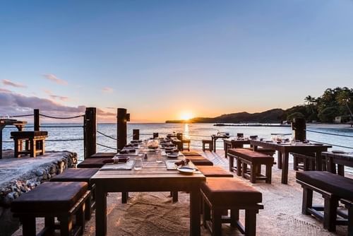 Dining & lounge area arranged by the sea overlooking the sunset at Warwick Fiji