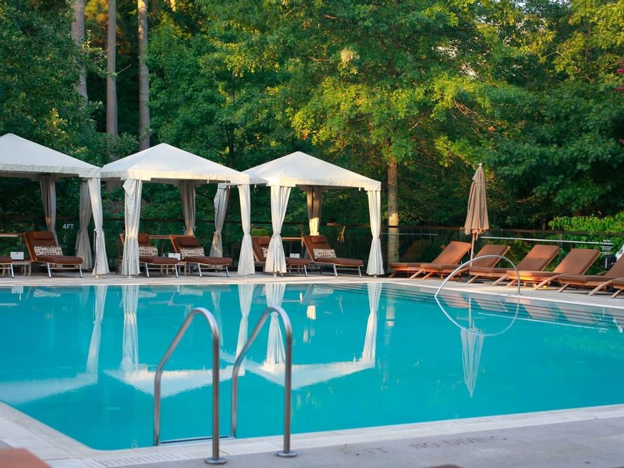 Outdoor pool area with lounge chairs & cabanas at Umstead Hotel and Spa
