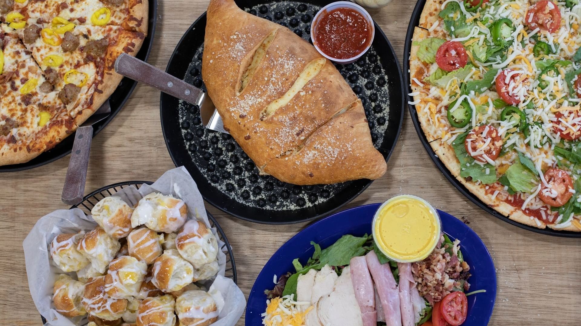 Close-up view of pizza, bread and sweets in Bruno’s Pizzas at Watersound Inn