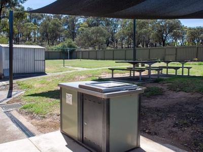 Outdoor picnic area with shaded seating and barbeque at La Trobe University - Orde House.