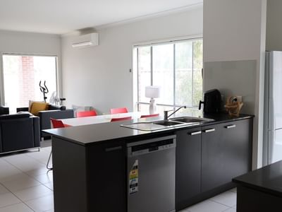 Modern kitchen with dining area and living room at La Trobe University Regional Housing.