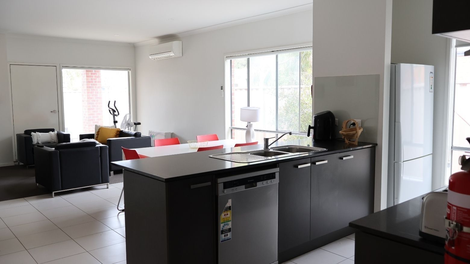 Modern kitchen with dining area and living room at La Trobe University Regional Housing.