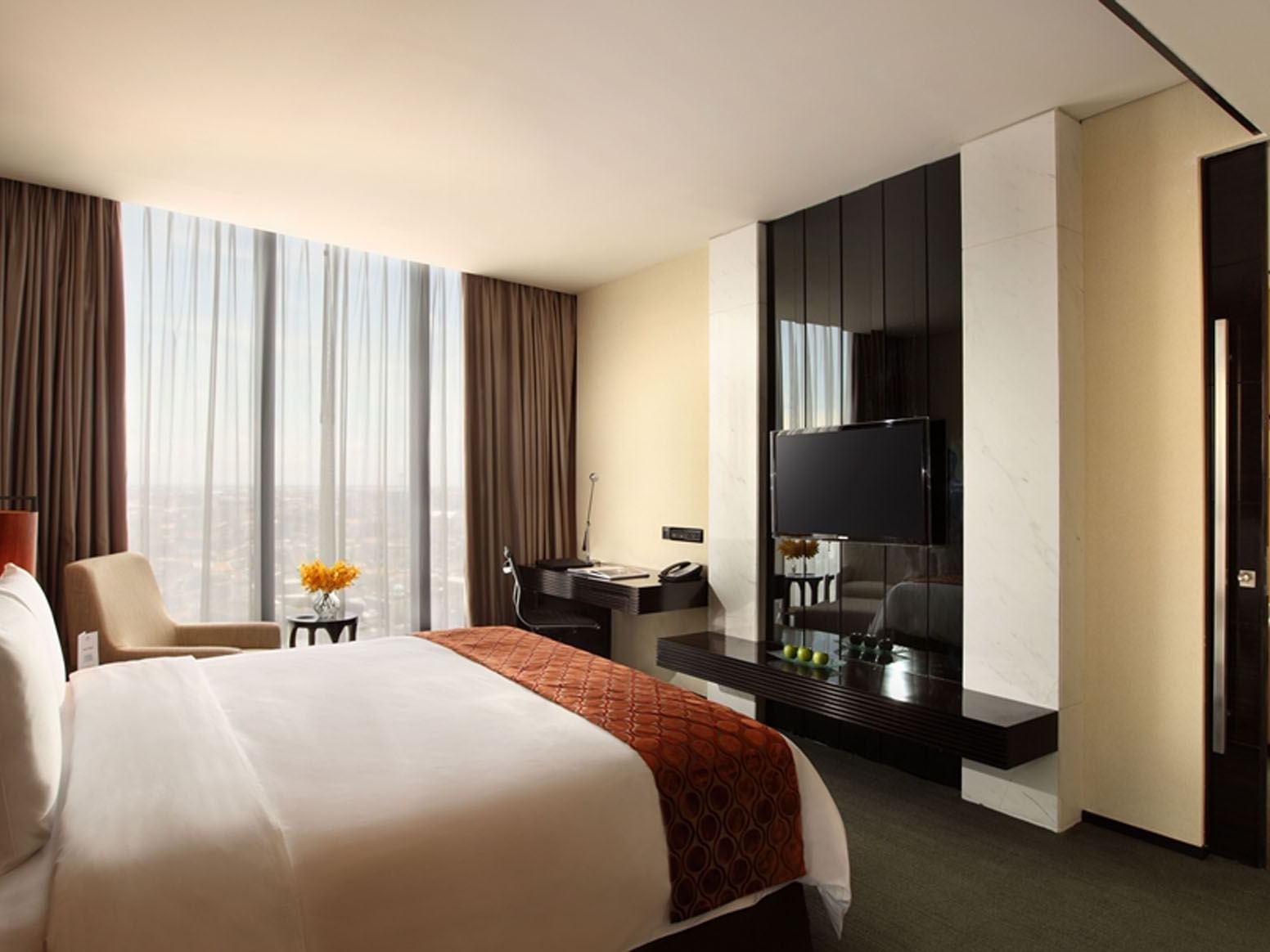 Bed and TV with work area in Executive Suite at Po Hotel Semarang