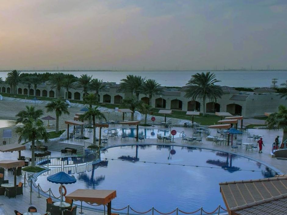 Outdoor pool with dining at Mena Al Hamra Jeddah Hotel