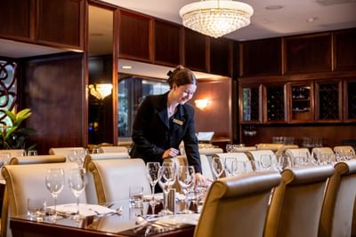 A friendly staff member at the Royal on the Park Hotel setting a beautiful table for an event or dinner service