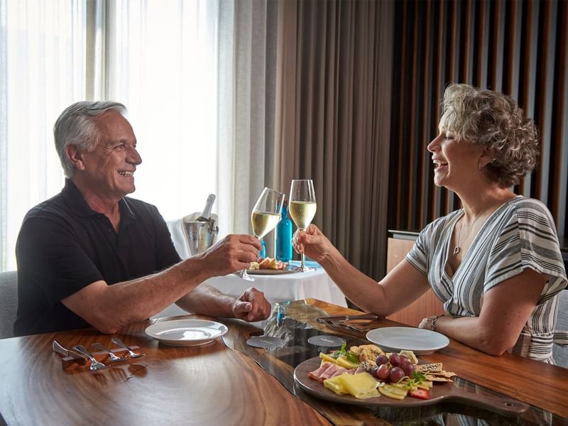 An older couple raising their glasses in a toast at Fiesta Americana