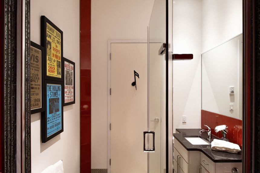 Bathroom vanity & framed concert posters on the wall in Queen Premiere Rock & Roll at Retro Suites Hotel