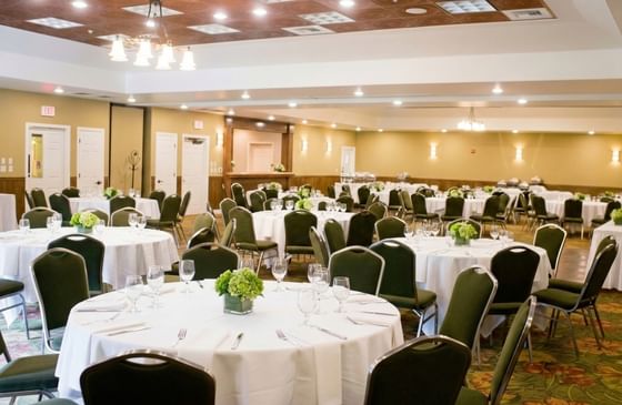 Dozens of elegant round dining tables with green chairs fill an Orchid ballroom at Oregon Garden Resort