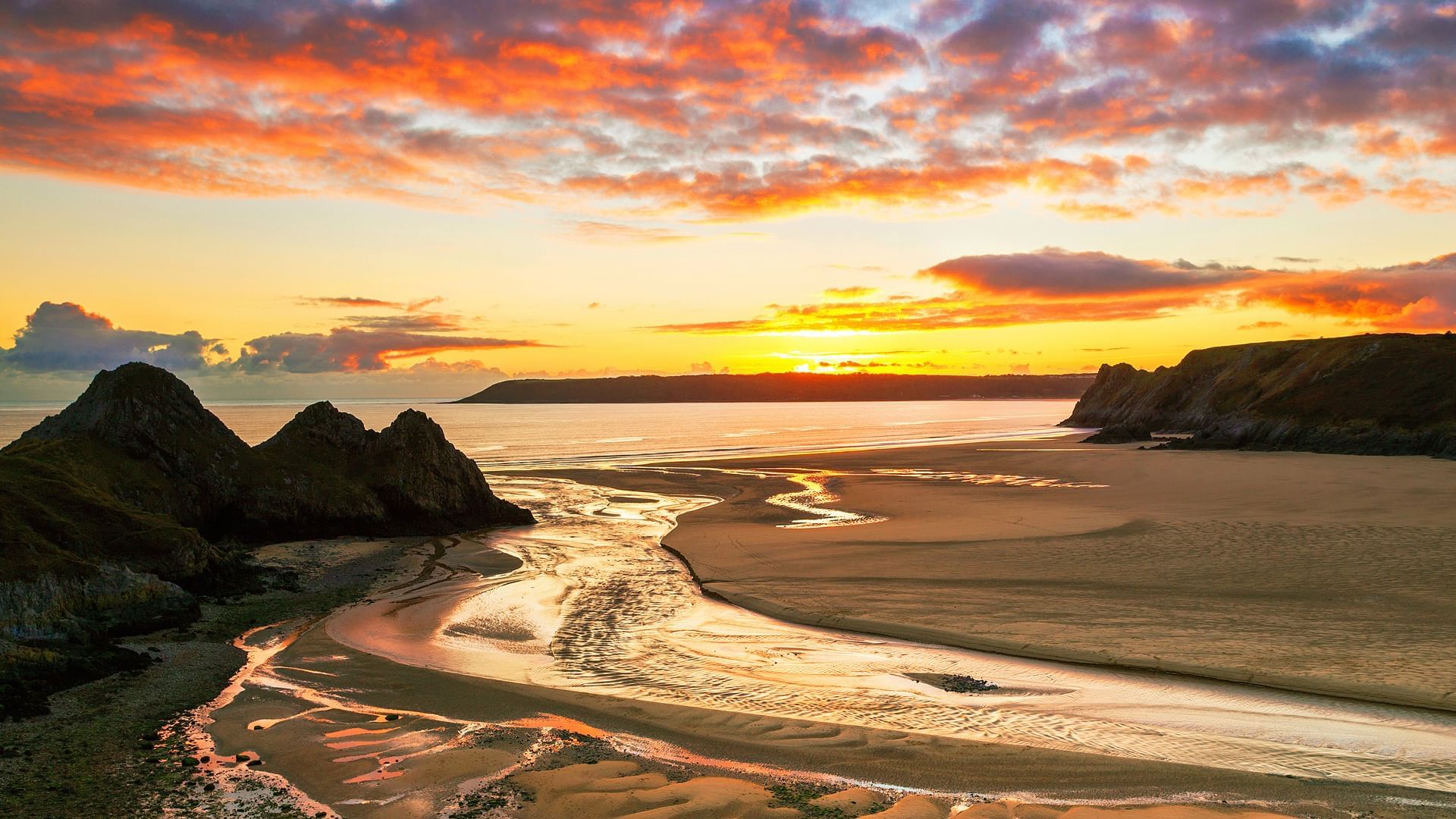 Landscape of beach near Village Hotels Swansea during sunset