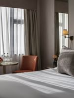 Cozy Standard Room with bed by a fruit table and orange chair at The Capital Hotel, Apartments & Townhouse