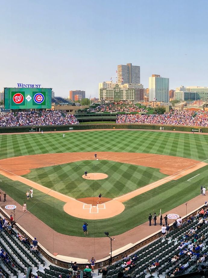 Le stade Wrigley Field bondé lors d'un match de baseball, avec des joueurs sur le terrain.