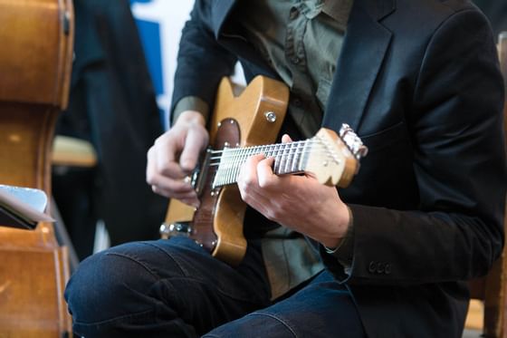 A Man playing the guitar near Granville Island Hotel