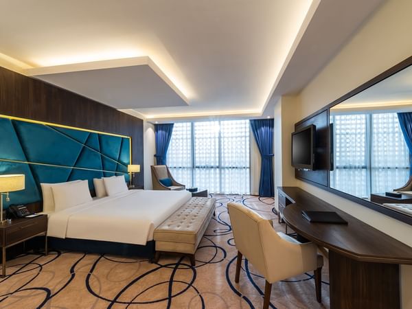 Deluxe Suite with cozy bed and TV area at Warwick Riyadh