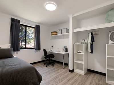 A neat room with bed, desk, chair, shelves, and closet at UniLodge at Curtin University - Erica Underwood House.