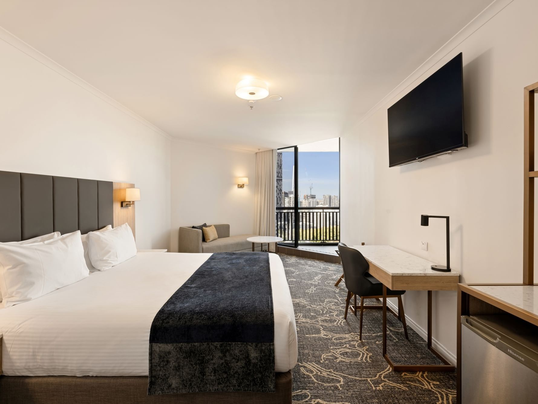 King Bed with side lamps and nearby sofas in Family Room at Hotel Grand Chancellor Brisbane