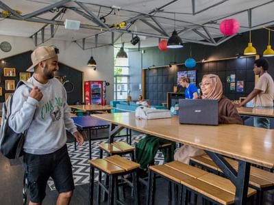 Students enjoying Ilam Student Accommodation's lounge with communal tables, seating, and a vibrant atmosphere.