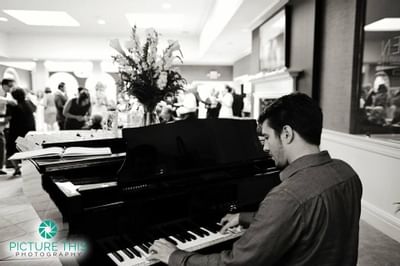 A man playing a piano in a wedding event at Ethan Allen Hotel