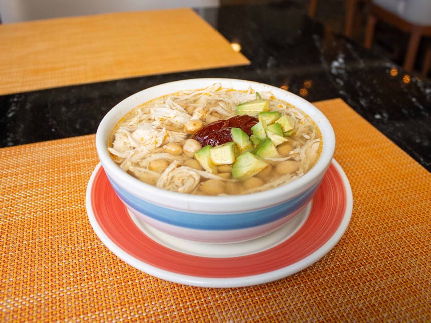 Primer plano de un cuenco de sopa tradicional con pollo y aguacate en el interior de Cafetería Palmira de Araiza Calafia