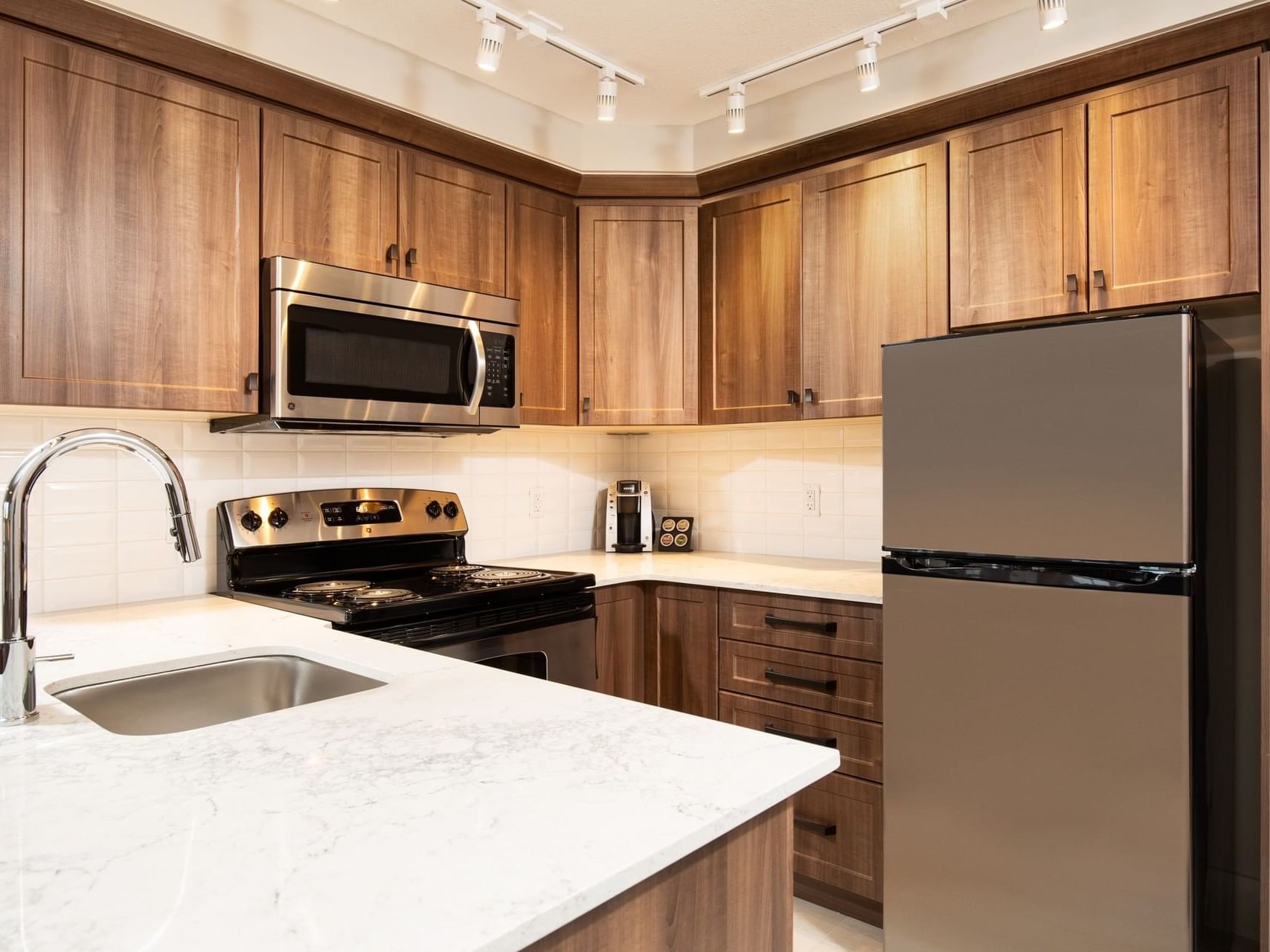 a refrigerator, microwave, and stove in a kitchen