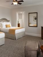 Two double beds by a wood TV stand under a classic ceiling fan in classic double at Warwick Melrose Dallas