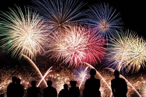 Spectators watch red, white, and blue fireworks, like those that will be on display during Fireworks at the Fountain on the 4th of July in Orlando.