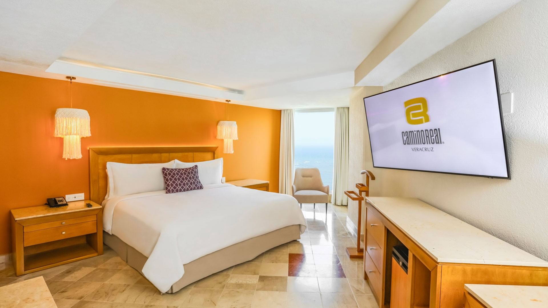 A luxurious hotel room with a large bed and ocean view at Camino Real Veracruz.