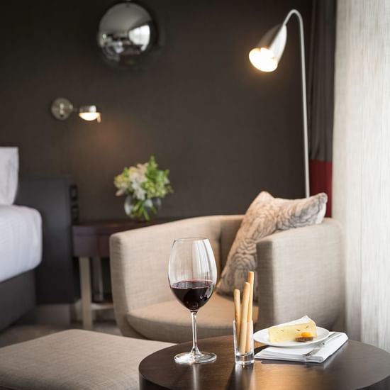 Close-up of a table with cheesecake and wine on it in a room at Melbourne Albert Park