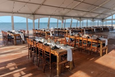 Wooden tables in a beachside tent for scenic PEI meetings and conventions at Rodd Crowbush Golf & Beach Resort