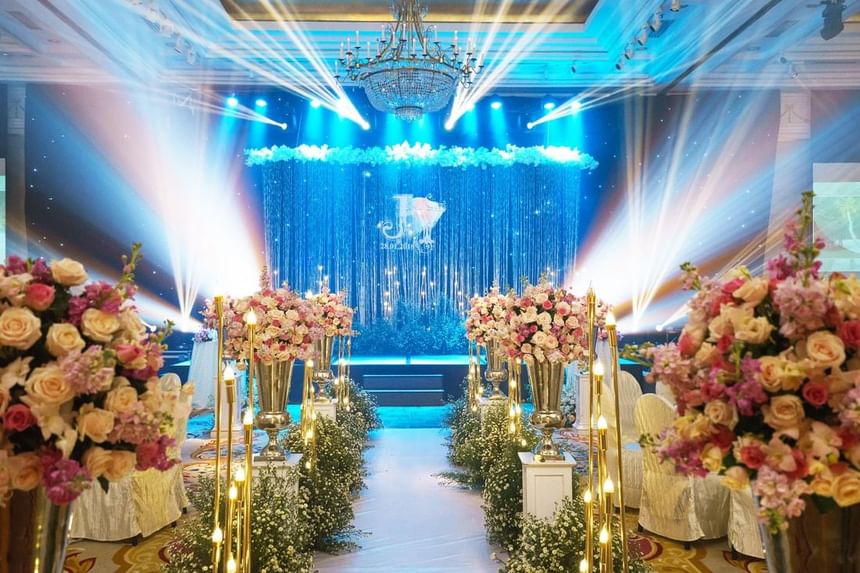 A decorated event space with floral arrangements, elegant lighting, and a sparkling backdrop at Park Hyatt Saigon