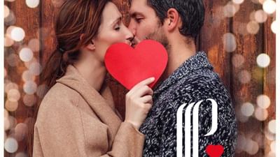 Couple enlacé avec coeur rouge devant bois, affichant Escapade Saint Valentin.