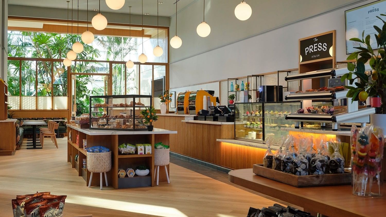 Contemporary café space with natural light, relaxed seating, and grab-and-go offerings.