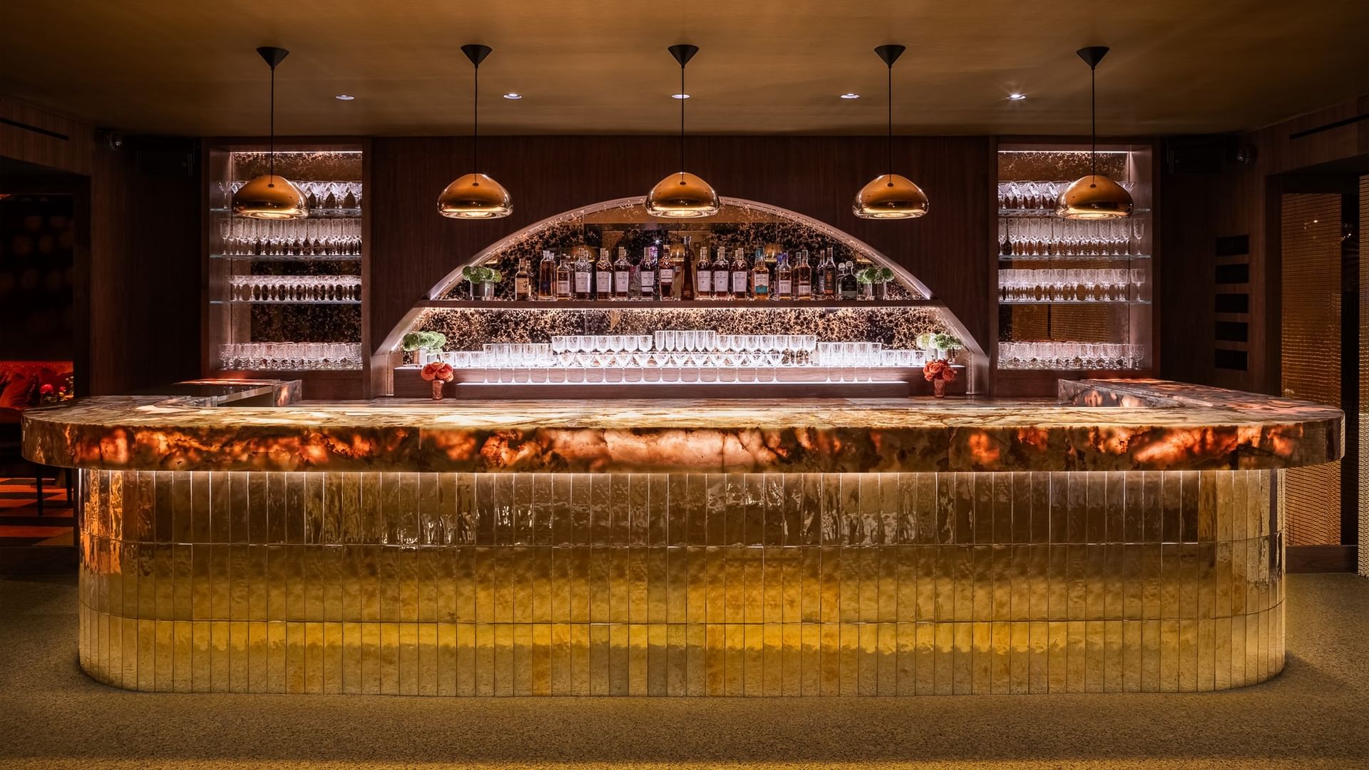 Dimes event room featuring a curved gold-paneled bar with copper pendant lights at Gansevoort Meatpacking NYC - NEW