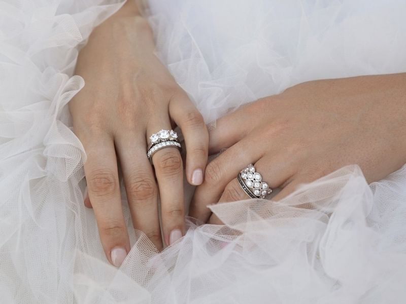 Close-up of hands with diamond rings on white tulle fabric at Pullman Port Douglas