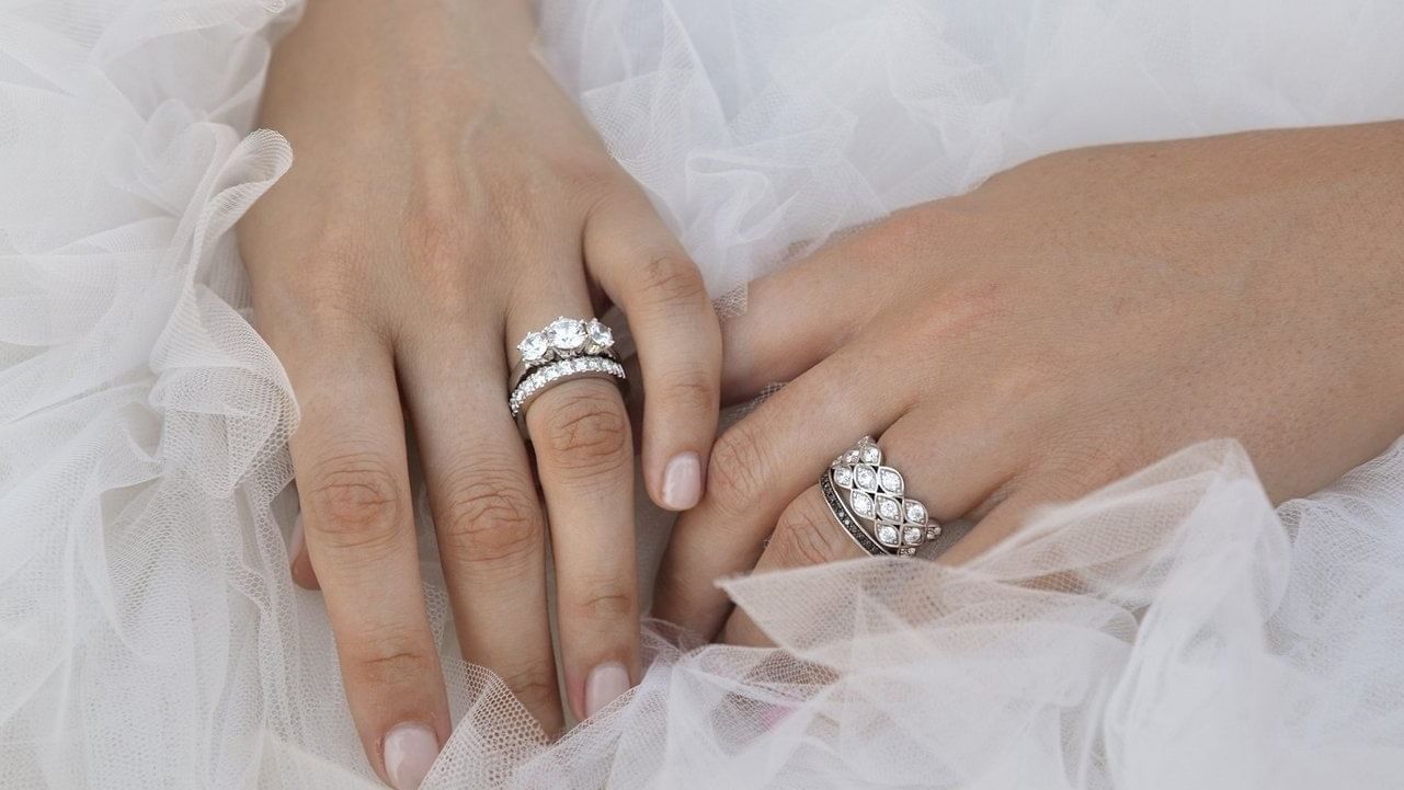 Close-up of hands with diamond rings on white tulle fabric at Pullman Port Douglas