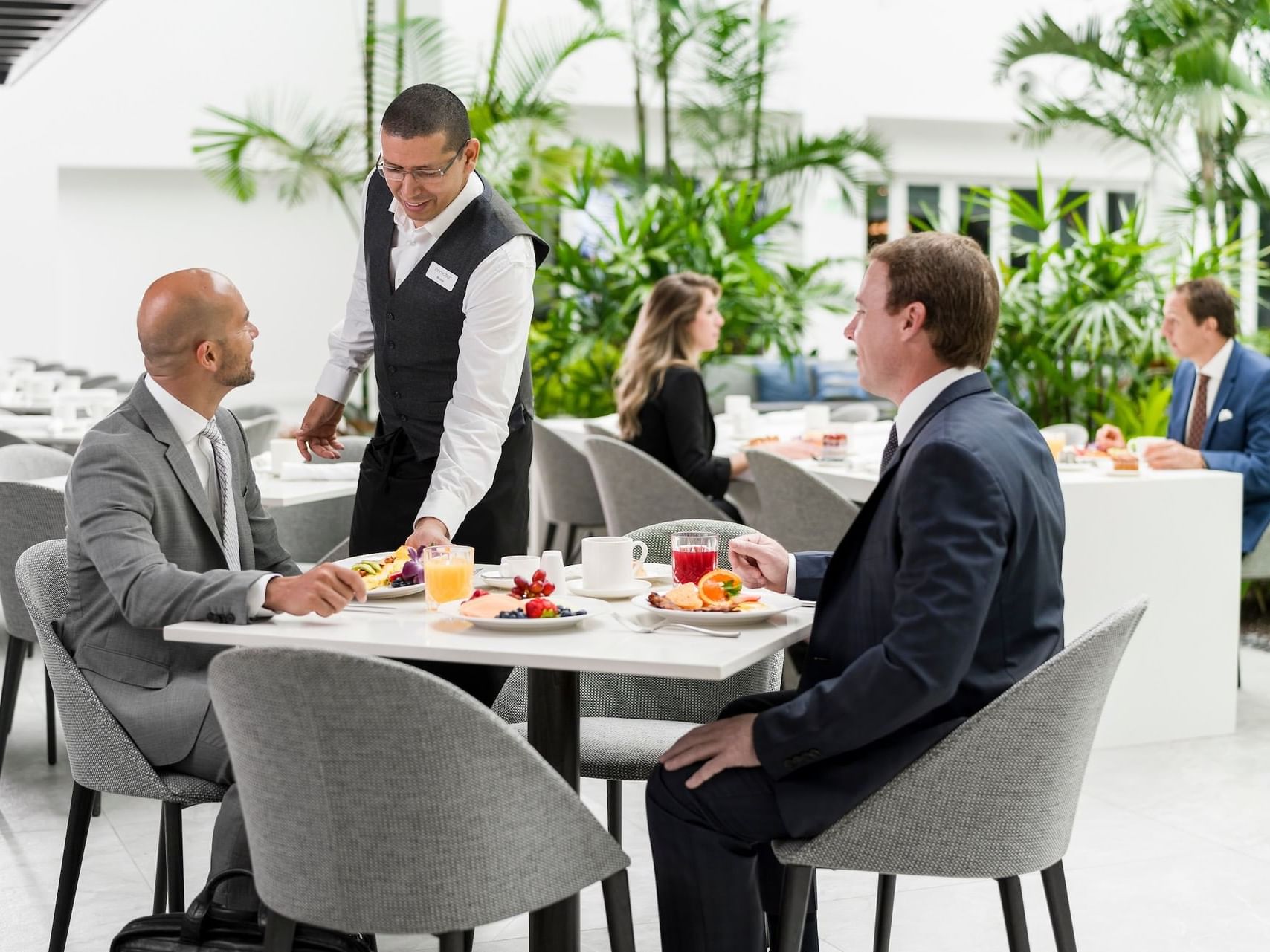 Waiter serving guests at Corkscrew Cafe at Innovation Hotel