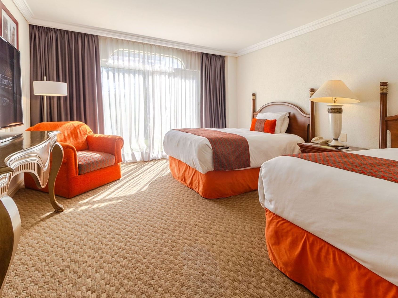 Sunny 2 Double Camino Real Club with an orange armchair and light-filtering curtains at Camino Real Puebla Angelopolis