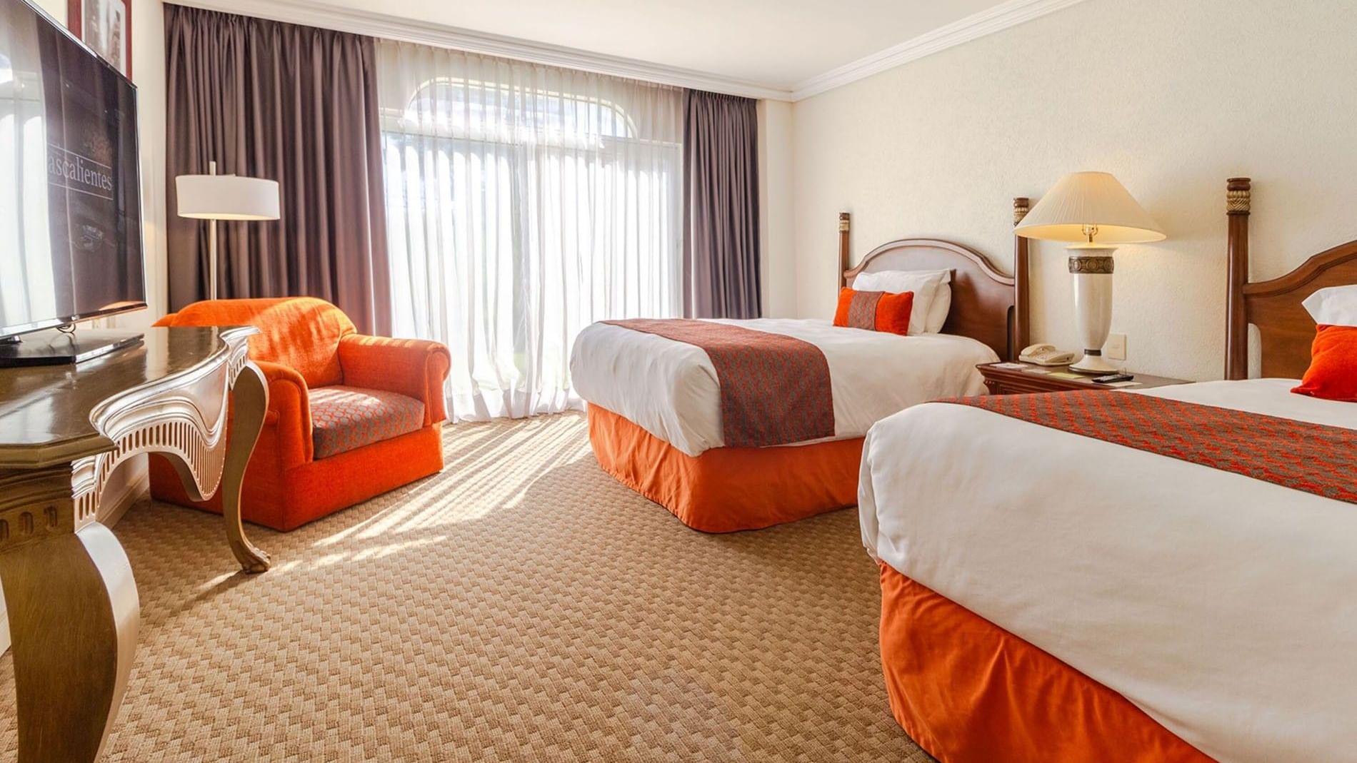 Sunny 2 Double Camino Real Club with an orange armchair and light-filtering curtains at Camino Real Puebla Angelopolis