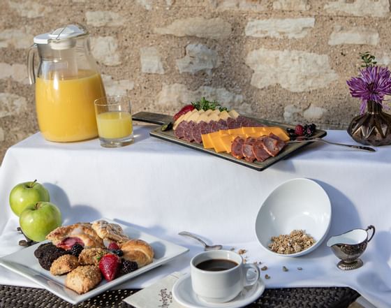 juice, fruit, and pastries at a breakfast buffet