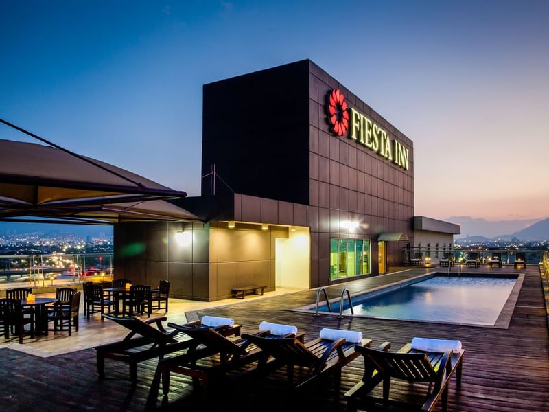 Rooftop Swimming pool with pool chairs at Fiesta Inn