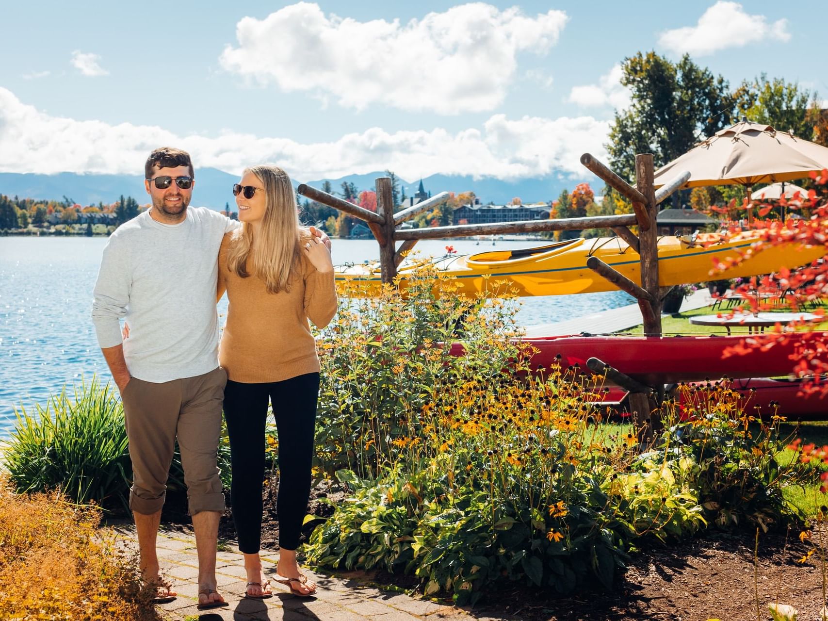 Couple holding each other & walking by the lake in High Peaks Resort