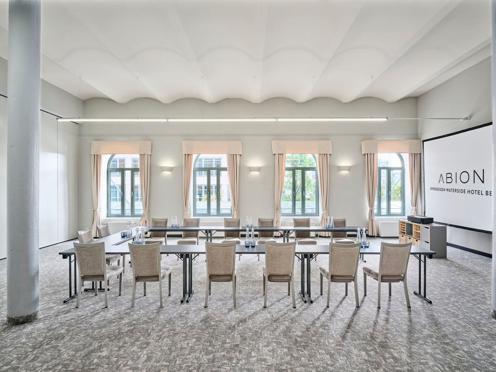 Meeting room setup with chairs and a long table at Abion Spreebogen Waterside Hotel Berlin.