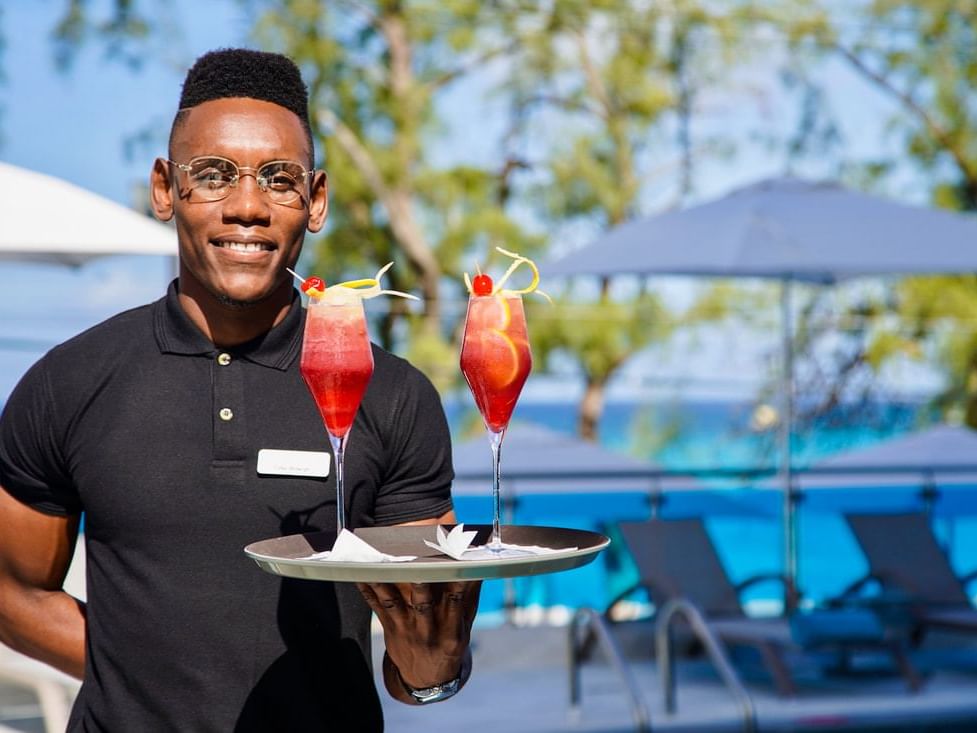 A bartender serving cocktails by he pool at The Abidah Hotel