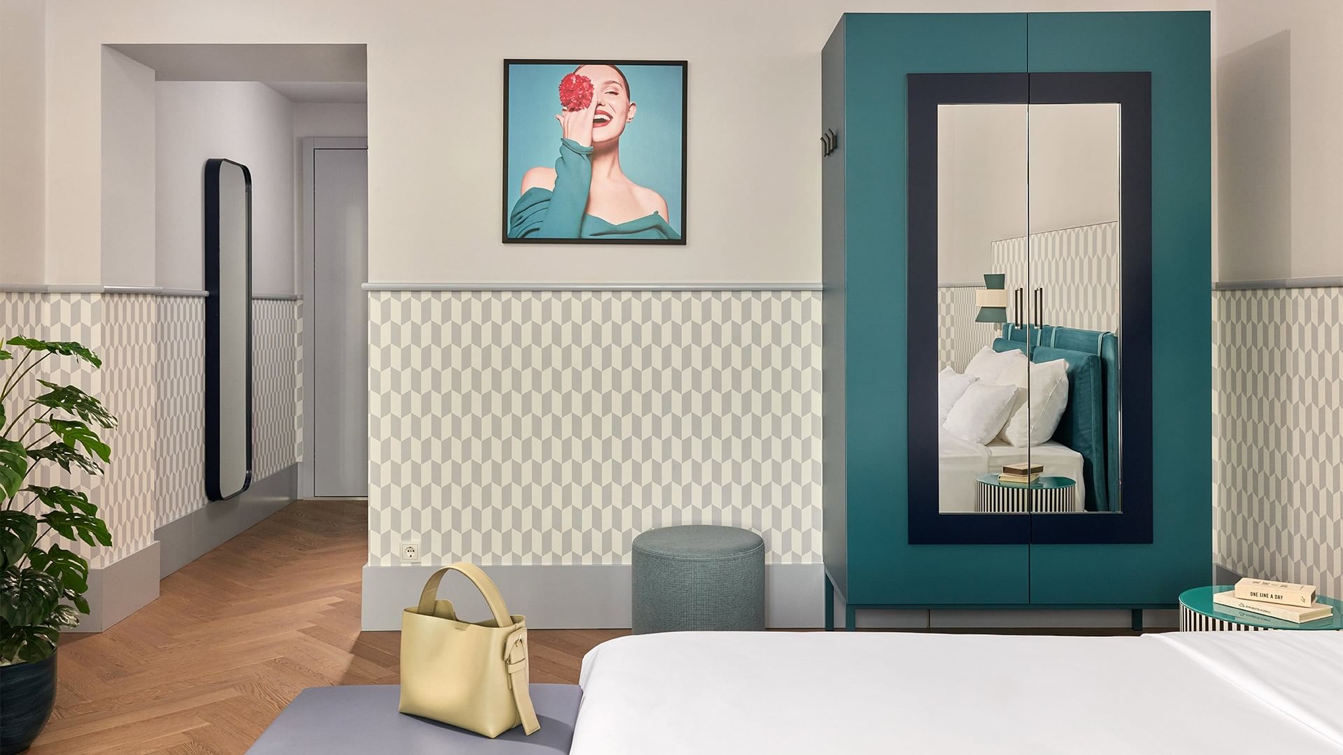 Pokoj Deluxe Room s postelí, skříní, zrcadlem a křeslem v hotelu Falkensteiner Hotel Prague.